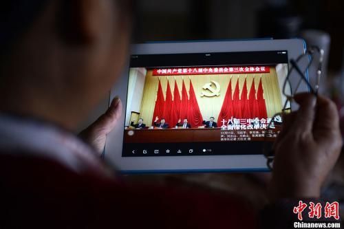 資料圖：一位網(wǎng)友用平板電腦瀏覽有關(guān)中國共產(chǎn)黨十八屆三中全會的報道。<a target='_blank'  data-cke-saved- >中新社</a>發(fā) 張浪 攝