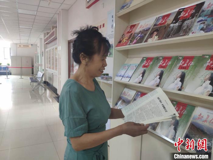 65歲的周云霞在社區(qū)看雜志打發(fā)時間?！∽T偉旗 攝